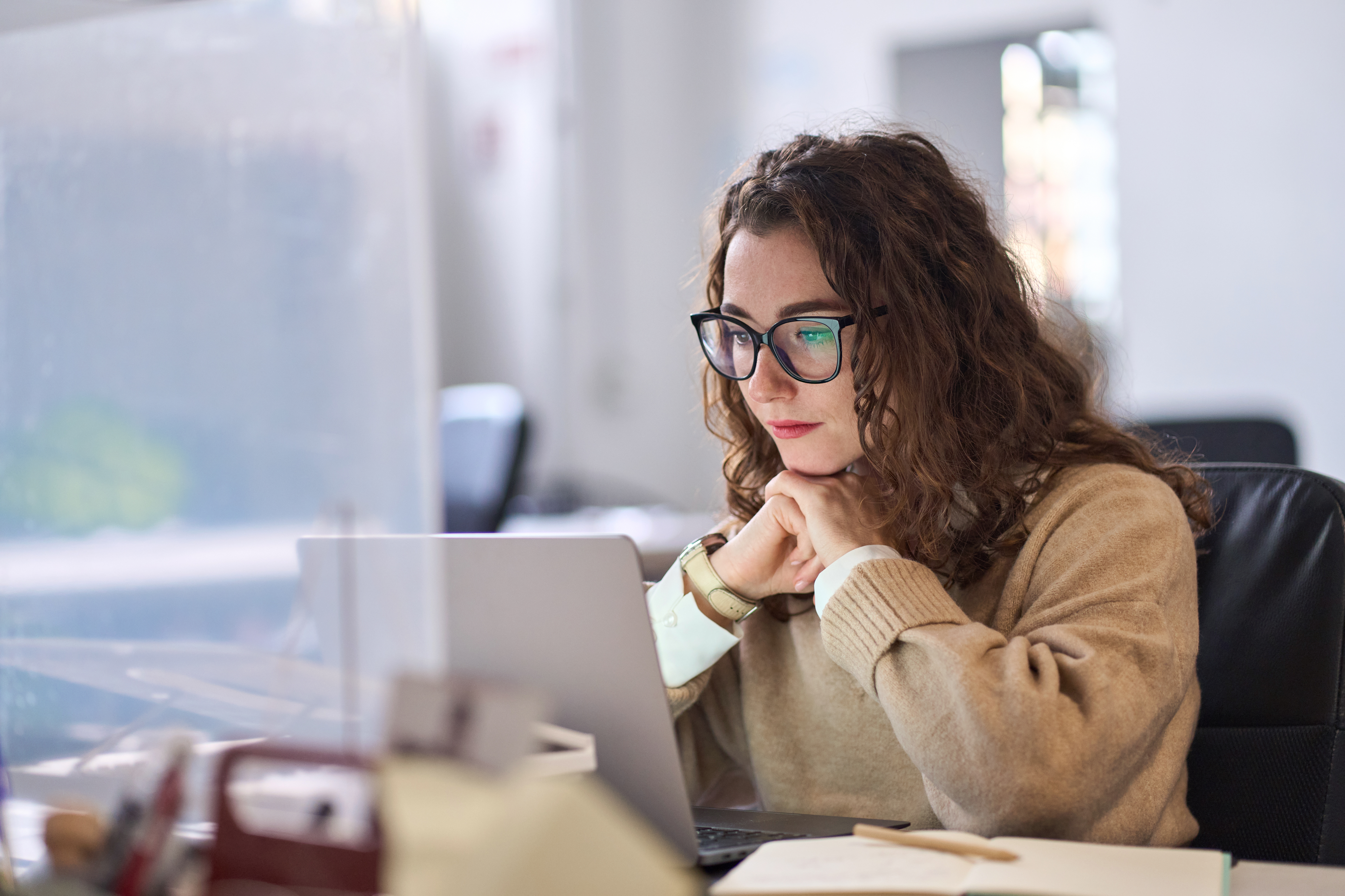 Woman sitting at a desk in front of a laptop